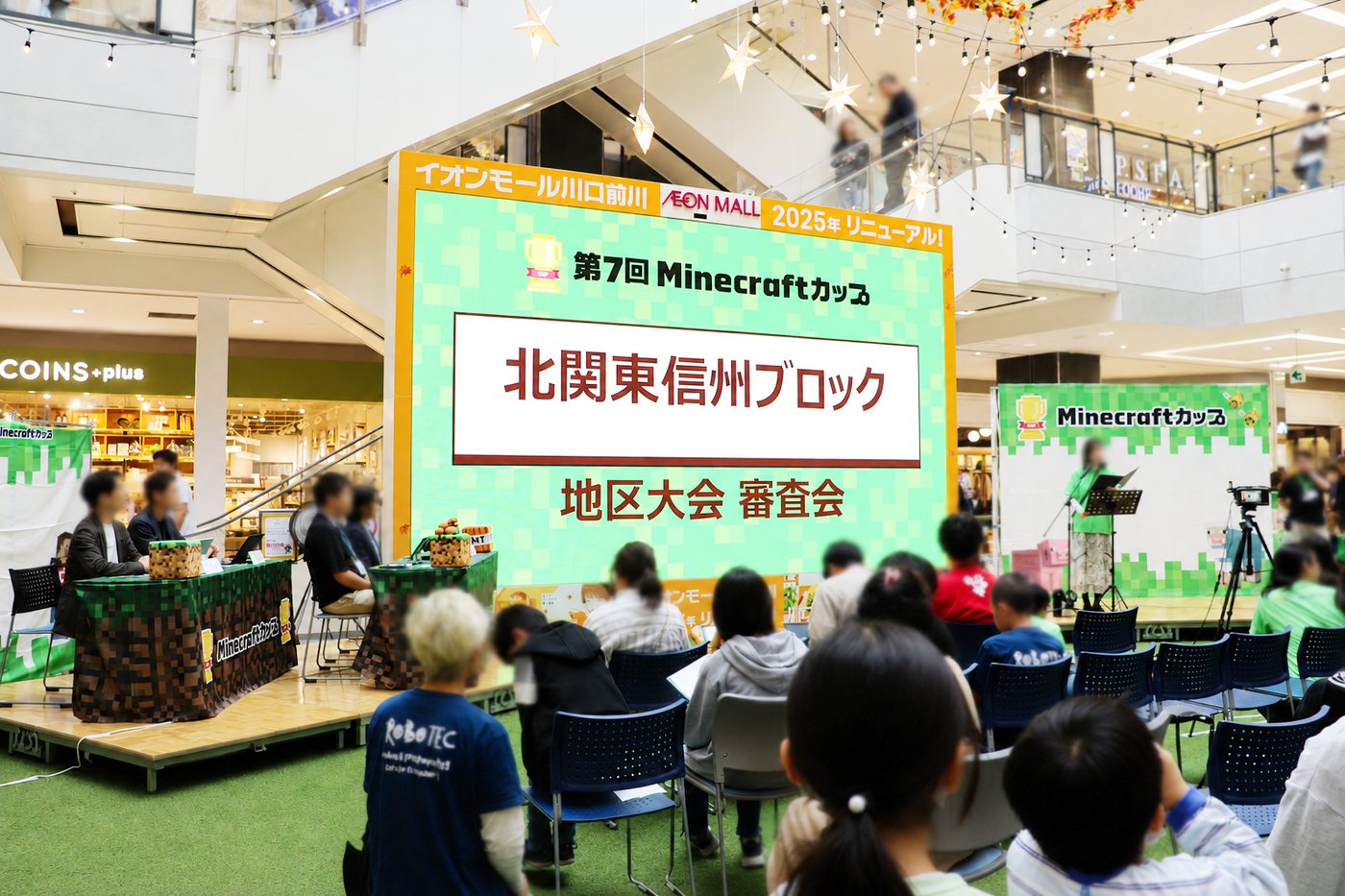第7回Minecraftカップ 北関東信州ブロック 地区大会 審査会の会場。大型スクリーンに大会名が映し出されている